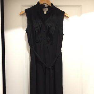 Sleeveless black dress with ruffled front.